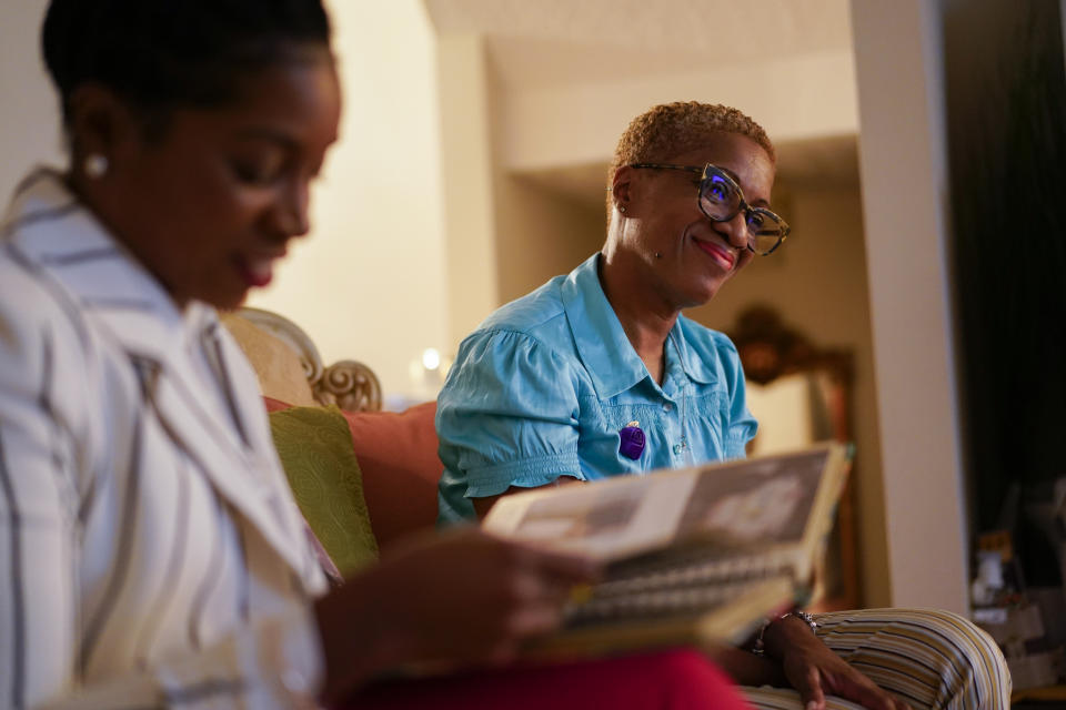 Nikiesha Thomas' sister Keeda Simpson, left, and mother Nadine Thomas look through family photos at Nadine's home in Olney, Md., Thursday, Aug. 25, 2022. Nikiesha Thomas was shot and killed by her ex-boyfriend just days after filing for a protective order last October. Victims of abuse and their families saw a quiet breakthrough this summer when the passage of a bipartisan gun safety bill in Congress included a proposal that would make it more difficult for intimate partners of convicted domestic abusers to obtain firearms. (AP Photo/Carolyn Kaster)