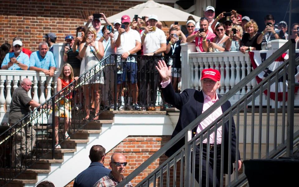Donald Trump waves to the crowd during the final round of the U.S. Women's Open golf tournament at Trump National Golf Club - Credit: USA Today