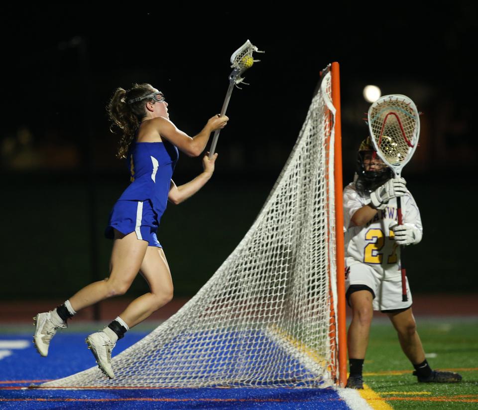 Queensbury's Brigid Duffy leaps as she passes the ball past Warwick goalie Abigail Tobin during Tuesday's Class B sub-regional game on May 31, 2022.