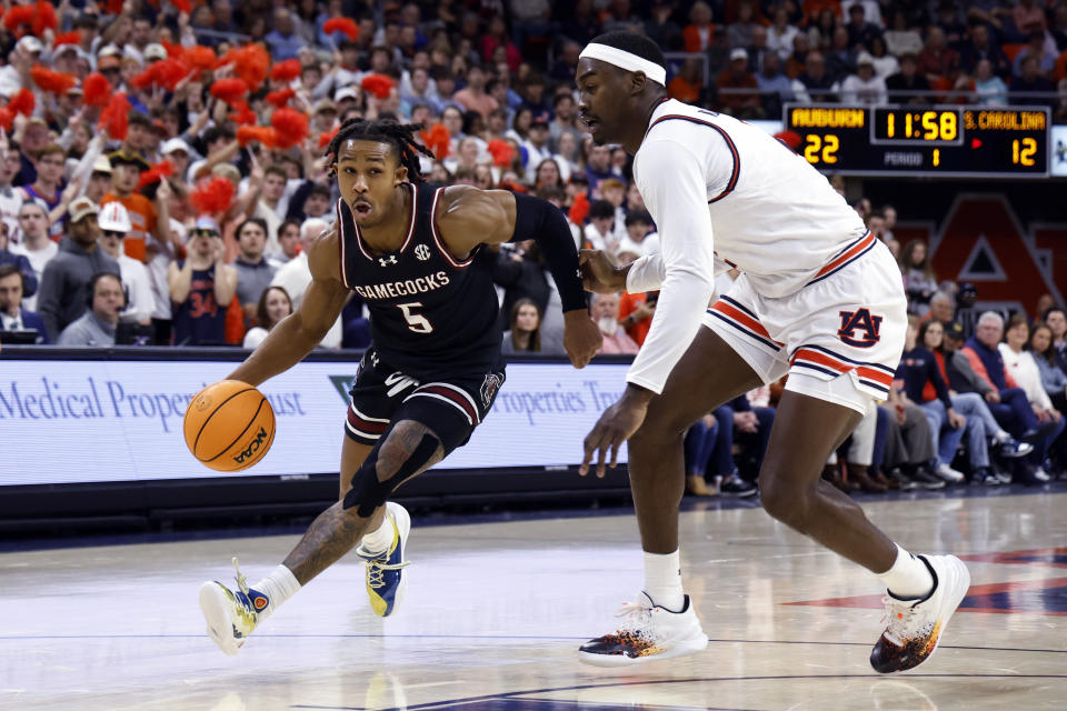 South Carolina guard Meechie Johnson (5) dribbles while moving around Auburn forward Jaylin Williams during the first half of an NCAA college basketball game Wednesday, Feb. 14, 2024, in Auburn, Ala. (AP Photo/Butch Dill)