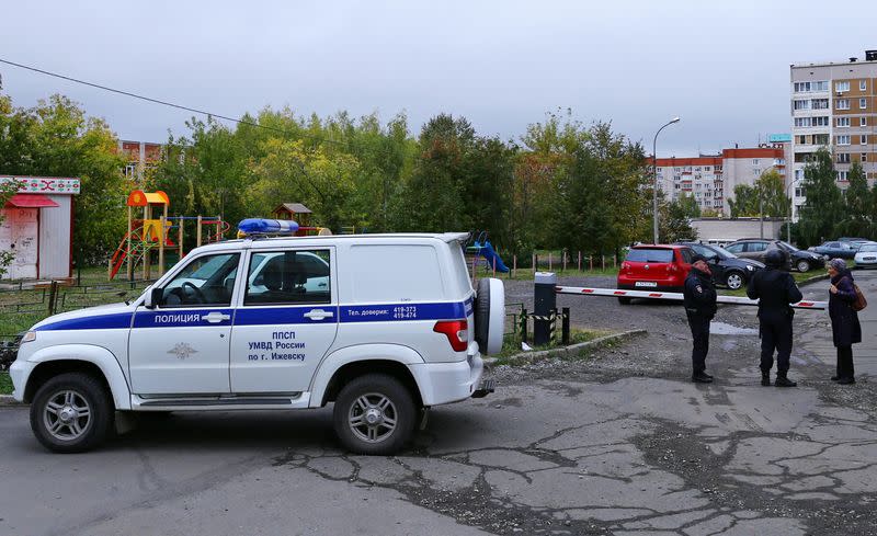 A woman talks to police officers securing area after a school shooting in Izhevsk