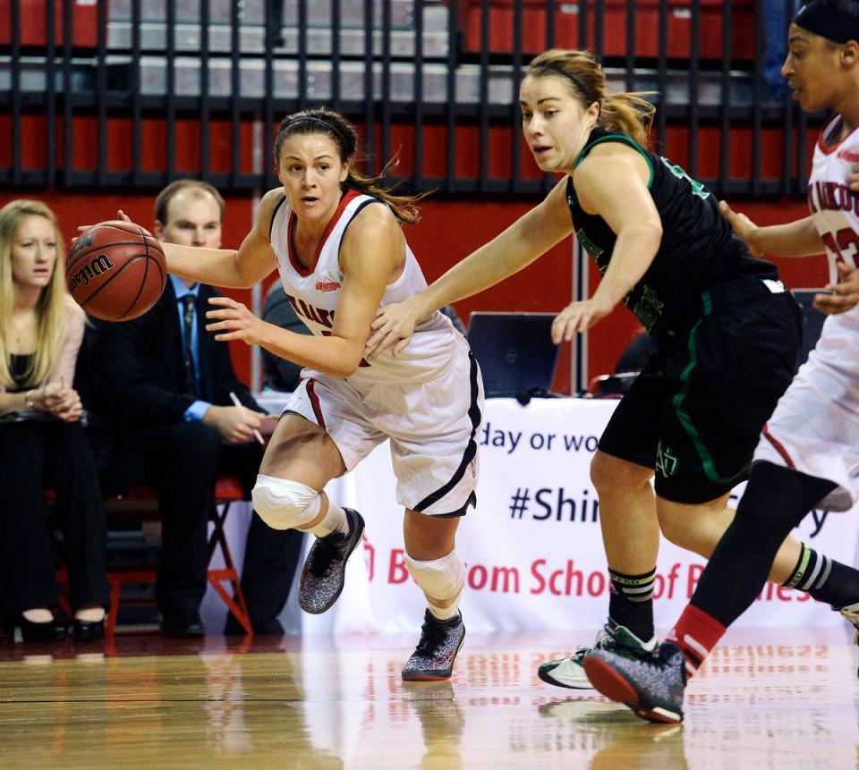 University of South Dakota guard Tia Hemiller charges down the court past North Dakota's Bailey Strand during a women's college basketball game on Dec. 21, 2014 in the DakotaDome at Vermillion.