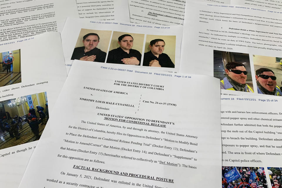 FILE - Pages from the Department of Justice motion to oppose the conditional release of Timothy Hale-Cusanelli ahead of his trial on charges stemming from the Jan. 6, 2021, riot at the U.S. Capitol, are photographed on May 24, 2022. A song featuring Donald Trump and a choir of prisoners charged with crimes related to the Capitol riot briefly took the No. 1 spot on iTunes last month, edging out Taylor Swift and Miley Cyrus. Just one choir member has been identified: Timothy Hale-Cusanelli, now serving four years in prison for his actions during Jan. 6. (AP Photo/Jon Elswick, File)