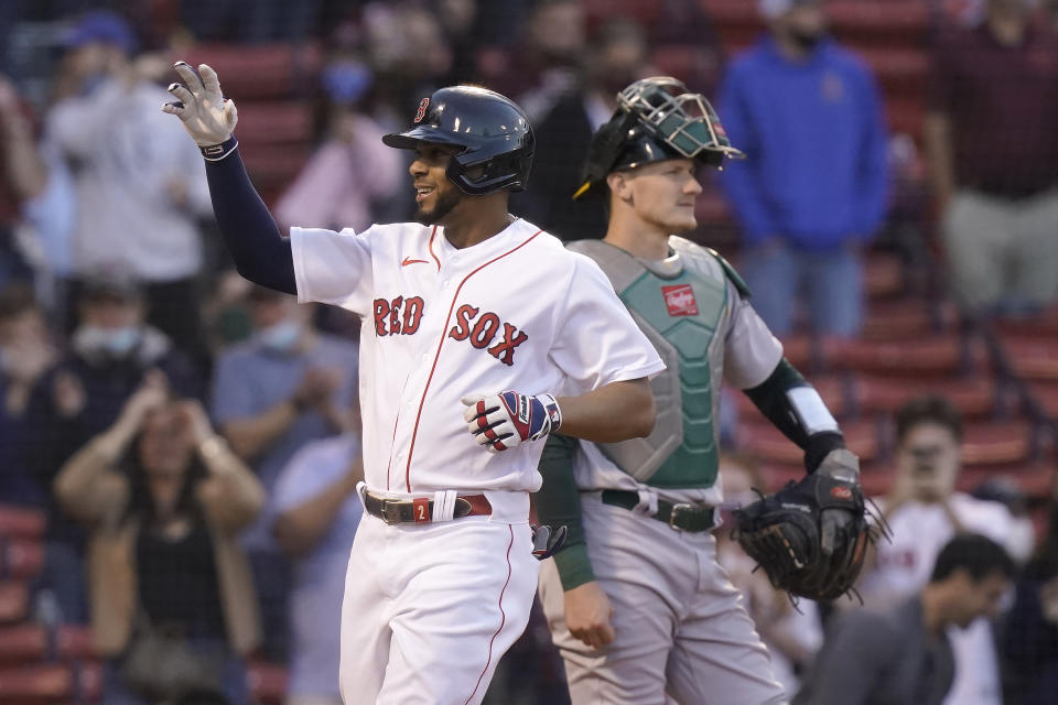 Boston Red Sox's Xander Bogaerts, left, celebrates as he arrives at home plate after hitting a two-run home run as Oakland Athletics' Sean Murphy, right, looks on in the first inning of a baseball game, Thursday, May 13, 2021, in Boston. (AP Photo/Steven Senne)