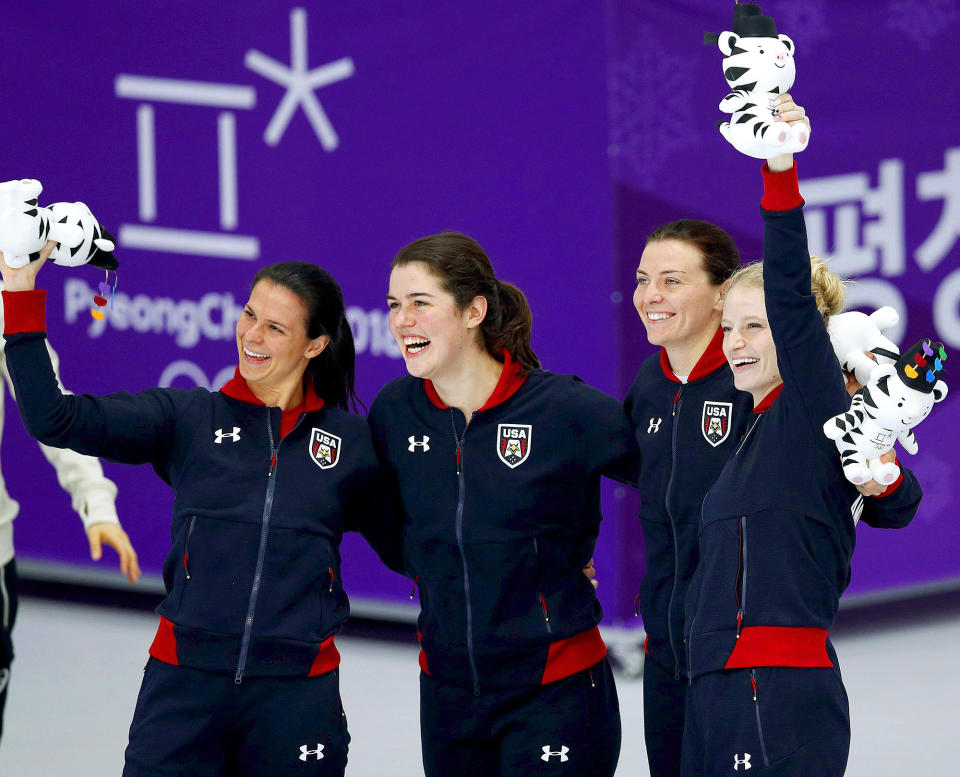 <p>American speed skaters Brittany Bowe, Carlijn Schoutens, Heather Bergsma, and Mia Manganello take the podium after winning bronze in the ladies' team pursuit event. </p>