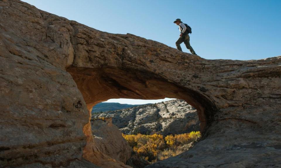 A man walks over a natural bridge at Butler Wash in Bears Ears near Blanding, Utah.