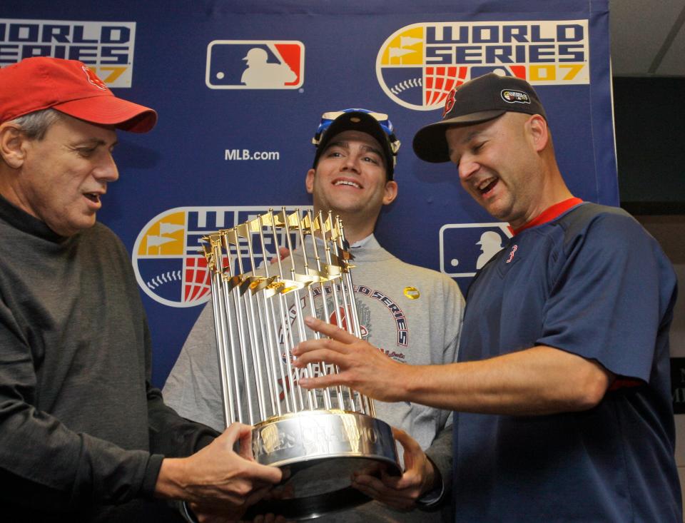 Red Sox president Larry Lucchino, left, general manager Theo Epstein, center, and manager Terry Francona hold the World Series trophy after Boston beat the Colorado Rockies 4-3, Sunday, Oct. 28, 2007, in Denver, to sweep the series 4-0.