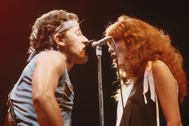 <p>Lynn Goldsmith/Corbis/VCG via Getty</p> Bruce Springsteen singing on stage with Patti Scialfa during a show in 1984.