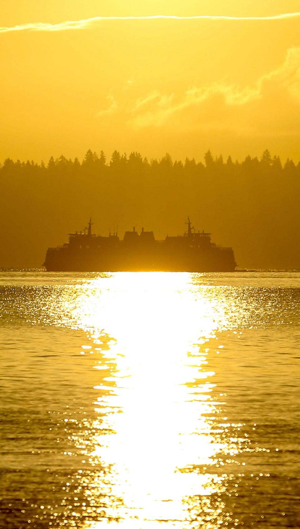 A Washington State Ferry leaving the Vashon dock is silhouetted in the sunshine as the boat heads for Faunleroy in March 2021. Regular service on the Triangle route is not expected to be restored until spring 2023 at the earliest, according to WSF.