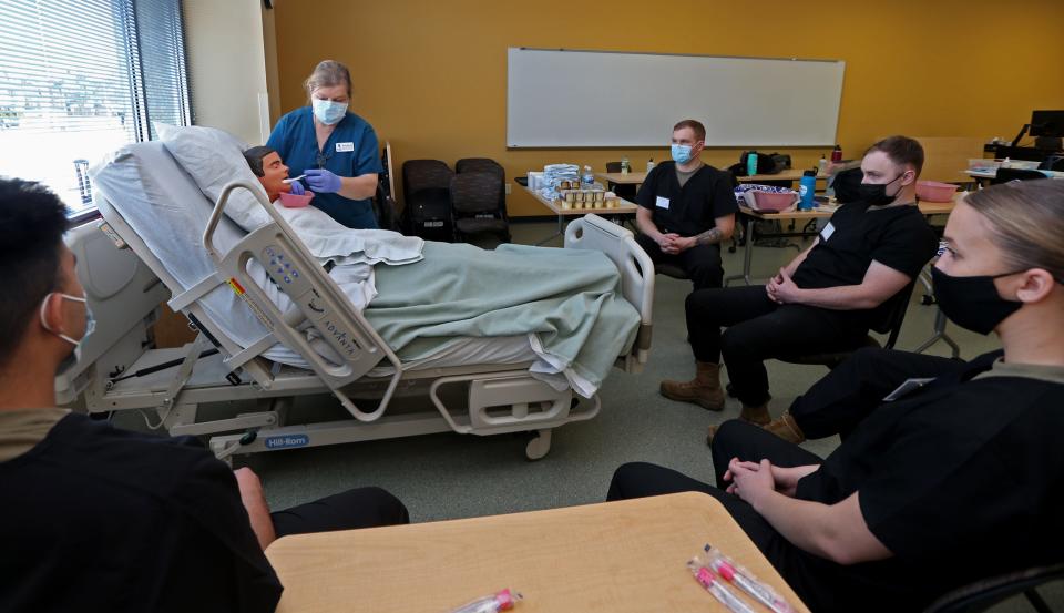 Nursing instructor Donna Dunnett shows Wisconsin National Guard members how to brush patient teeth during a personal care class at Madison College on Wednesday, Jan. 19, 2022. The guard members were training for their Certified Nursing Assistant certification in an effort to help support Wisconsin’s hospitals and nursing homes that have been strained during the pandemic. The 75-hour training curriculum will provide the 80 guard members with digital badges for nurse aide training and supervised practical training.