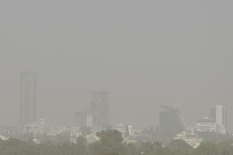 A haze caused by a dust covers the capital Nicosia, in the southeast Mediterranean island of Cyprus, on Monday, April 4, 2022. The U.N. health agency says nearly everybody in the world breathes air that doesn't meet its standards for air quality. The World Health Organization is calling for more action reduce fossil-use use that generate pollutants that cause respiratory and blood-flow problems and lead to millions of preventable deaths each year. (AP Photo/Petros Karadjias)