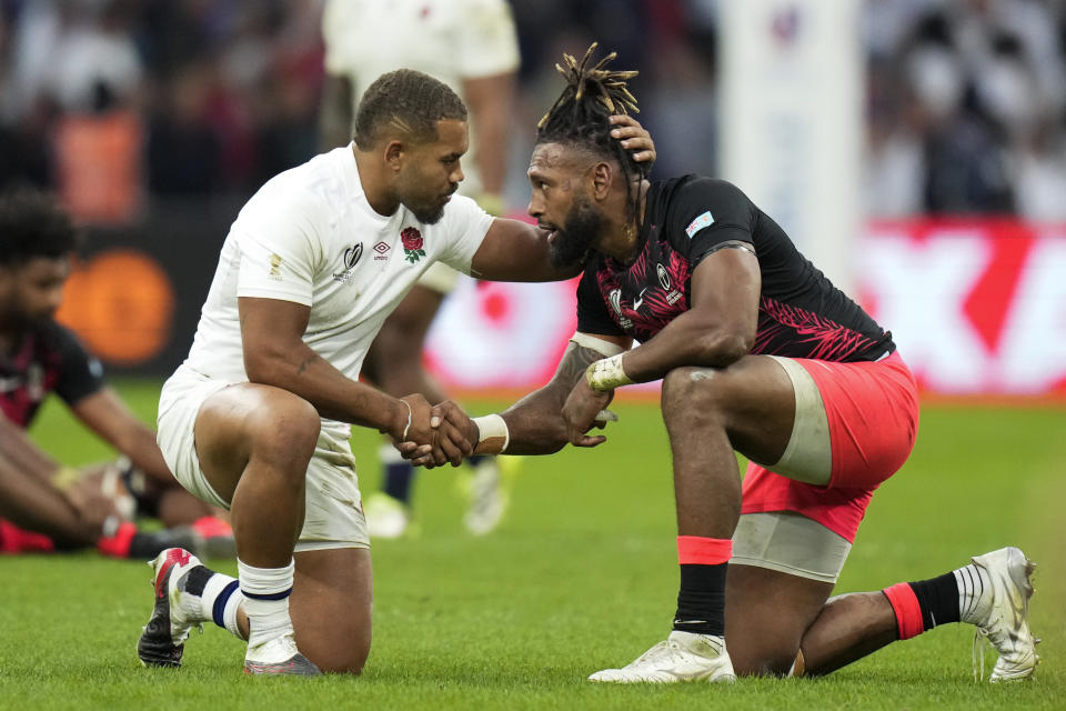 England's Ollie Lawrence, left, and Fiji's Waisea Nayacalevu hug at the end of the Rugby World Cup quarterfinal match between England and Fiji at the Stade de Marseille in Marseille, France, Sunday, Oct. 15, 2023. (AP Photo/Pavel Golovkin)