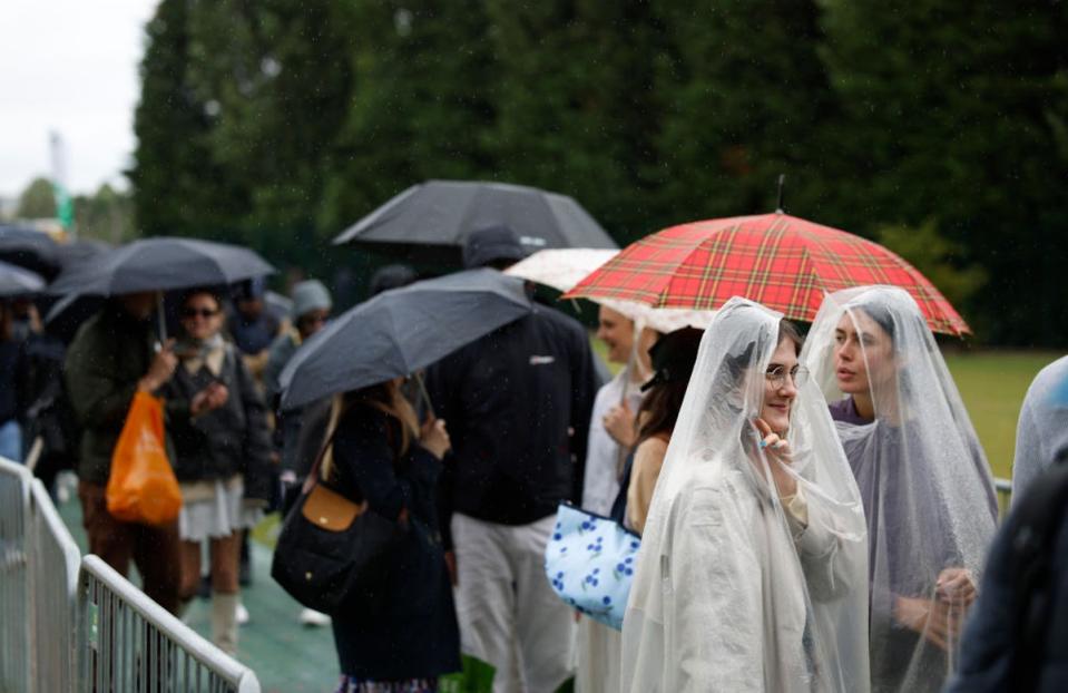 Fans shelter as they wait in the Wimbledon queue (Getty Images)