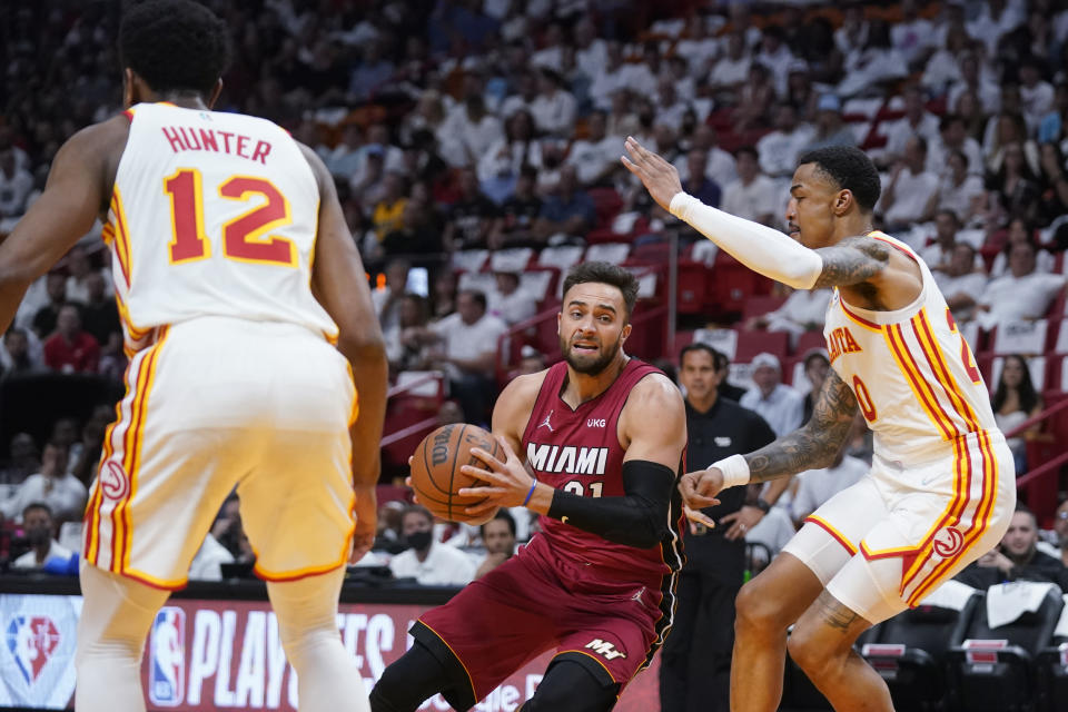 Miami Heat guard Max Strus, center, goes up for a shot against Atlanta Hawks forwards John Collins (20) and De'Andre Hunter (12) during the first half of Game 5 of an NBA basketball first-round playoff series, Tuesday, April 26, 2022, in Miami. (AP Photo/Wilfredo Lee)