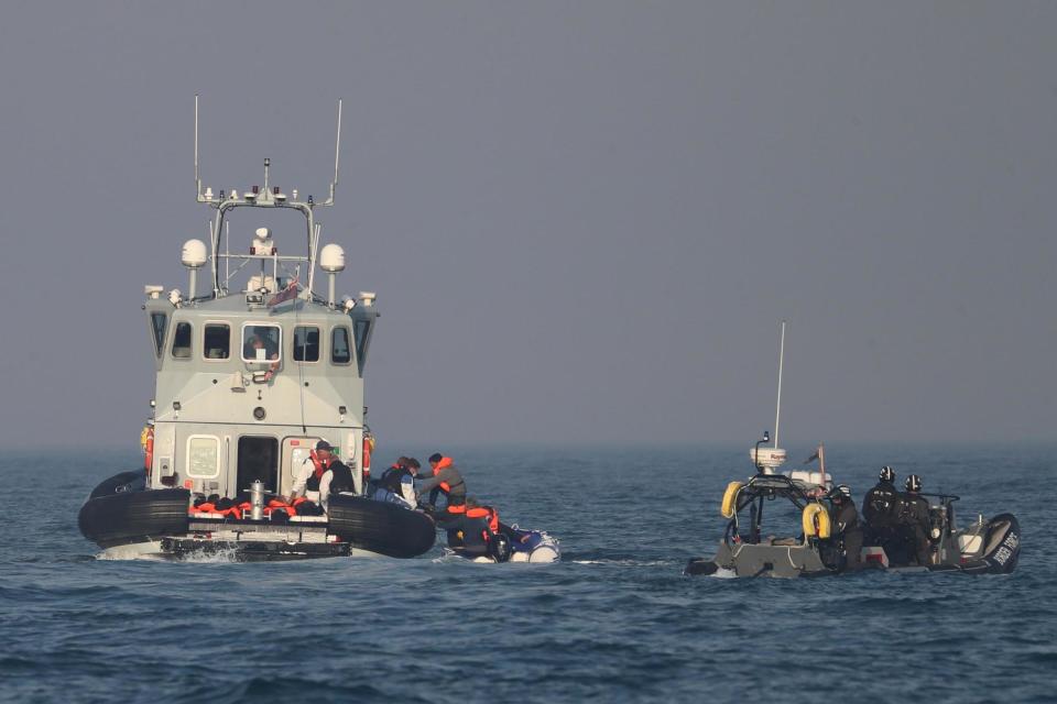 Border Force officers assist 20 Syrian migrants aboard HMC Hunter after they were stopped as they crossed the Channel (PA)