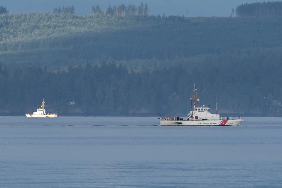 A pair of U.S. Coast Guard vessels searches the area Sept. 5, 2022, near Freeland, Wash., on Whidbey Island north of Seattle where a chartered floatplane crashed the day before.