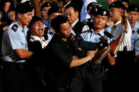 Student protest leader Joshua Wong shouts as he is carried by policemen as protesters are detained at a monument symbolising the city's handover from British to Chinese rule, a day before Chinese President Xi Jinping is due to arrive for the celebrations, in Hong Kong, China June 28, 2017. REUTERS/Damir Sagolj