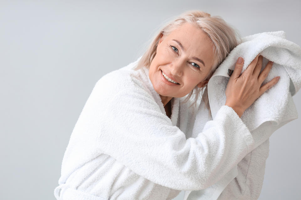 Happy woman in bathrobe and with towel