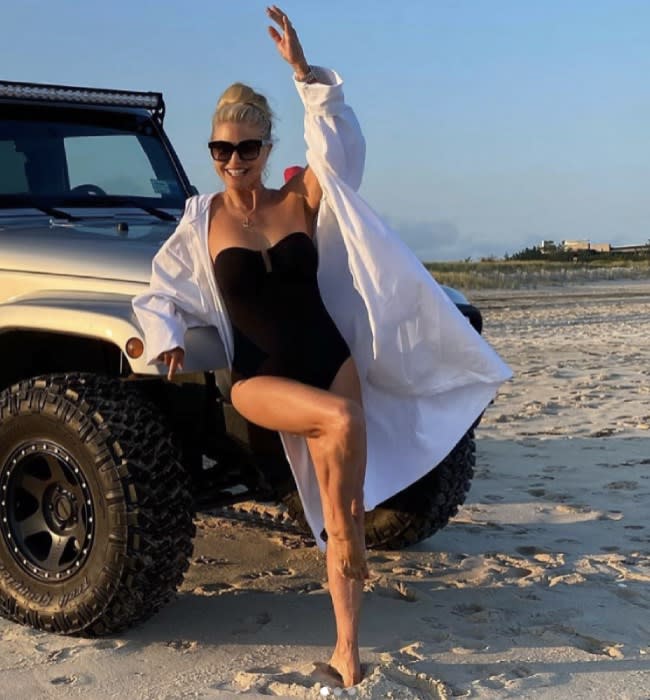 Christie Brinkley on the beach in a black swimsuit