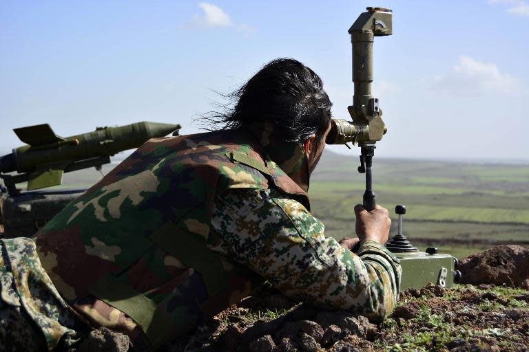 A member of the Syrian government forces looks at enemy positions from the Fatima hill overlooking the town of Kfar Shams, north of the southern Syrian city of Deraa on March 1, 2015, after they regained control of the hill the day before