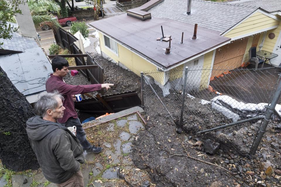 A 2021 rainstorm that hit the denuded landscape of a burn scar sent mud flowing into streets and yards in Silverado, California. <a href="https://www.gettyimages.com/detail/news-photo/two-men-survey-the-damage-from-mud-and-debris-that-ran-news-photo/1299356465" rel="nofollow noopener" target="_blank" data-ylk="slk:Paul Bersebach/MediaNews Group/Orange County Register via Getty Images;elm:context_link;itc:0;sec:content-canvas" class="link ">Paul Bersebach/MediaNews Group/Orange County Register via Getty Images</a>