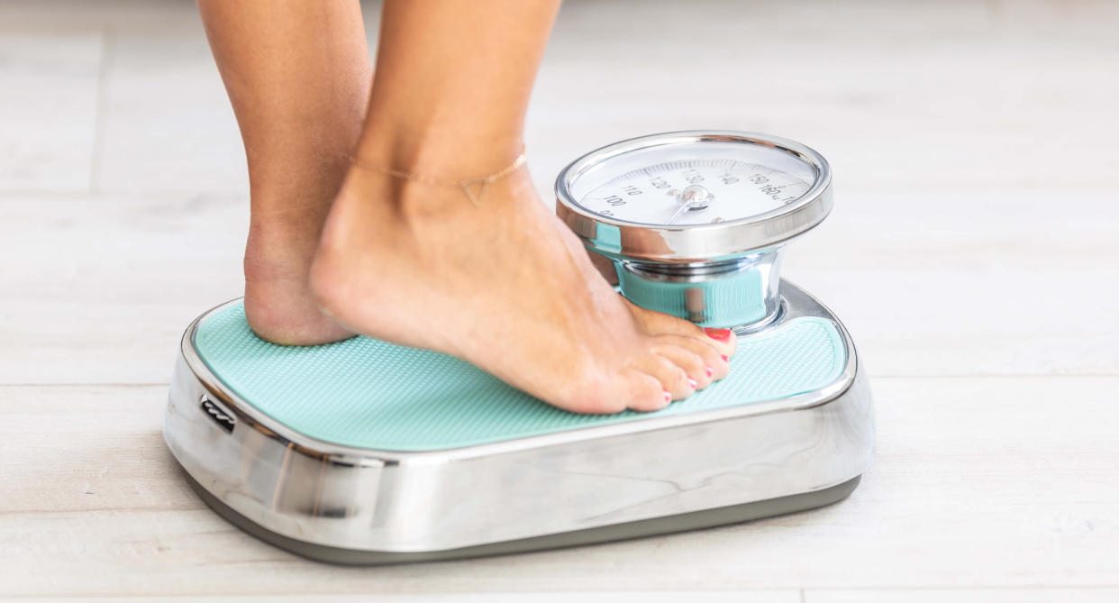 Woman stands on scales as study finds that weight gain and weight loss can affect life expectancy. (Getty Images)