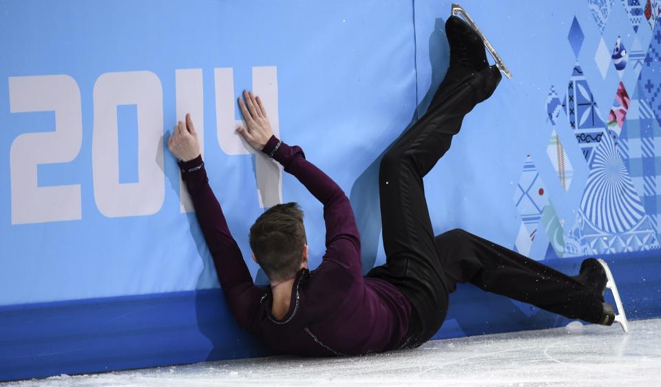 Jeremy Abbott of the United States, crashes into the boards after falling during the men's short program figure skating competition at the Iceberg Skating Palace during the 2014 Winter Olympics, Thursday, Feb. 13, 2014, in Sochi, Russia. (AP Photo/The Canadian Press, Paul Chiasson)