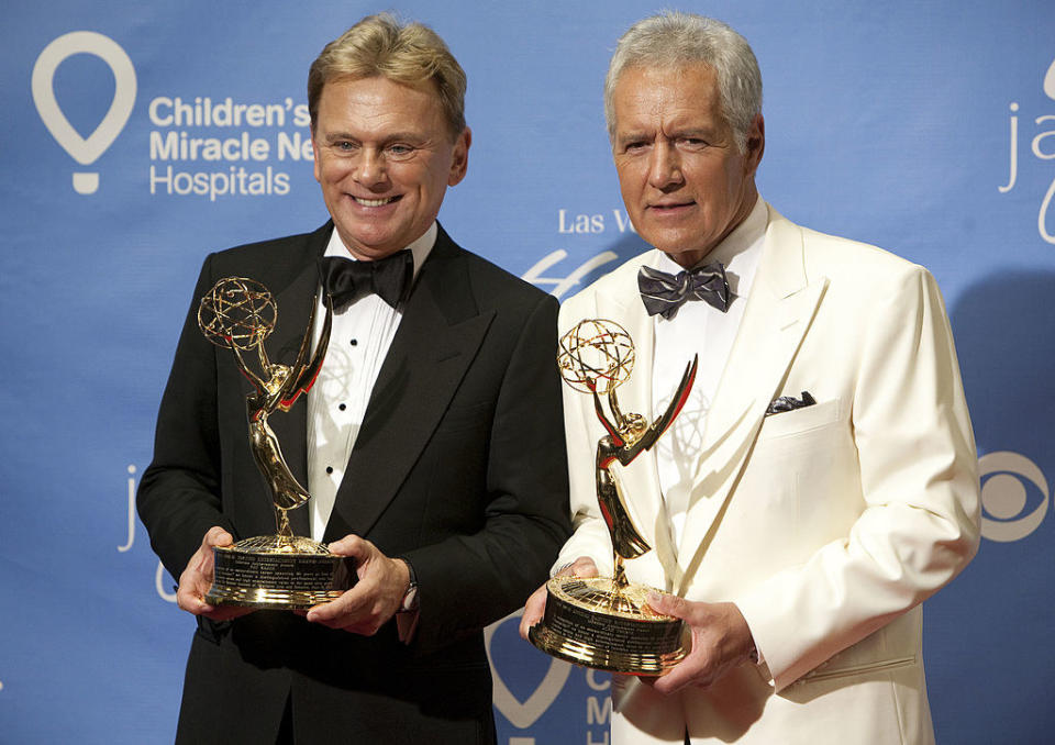 Alex Trebek and Pat Sejak posing together with Emmy awards