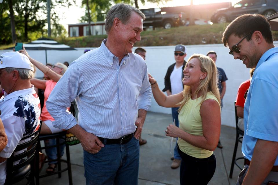 Republican gubernatorial candidate David Perdue and Rep Marjorie Taylor Greene speak to each other during a Bikers for Trump campaign event held at the Crazy Acres Bar & Grill on May 20, 2022 in Plainville, Georgia. Former U.S. Sen. David Perdue (R-GA) is running to unseat Georgia Gov. Brian Kemp and Rep. Greene is running for a second congressional term in the state's primary. (Photo by Joe Raedle/Getty Images) (Getty Images)