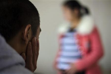 Lu Libing looks at his pregnant wife, Mu, as they pose for pictures during an interview with Reuters at their home in Ganzhou, Jiangxi province March 13, 2014. REUTERS/Alex Lee