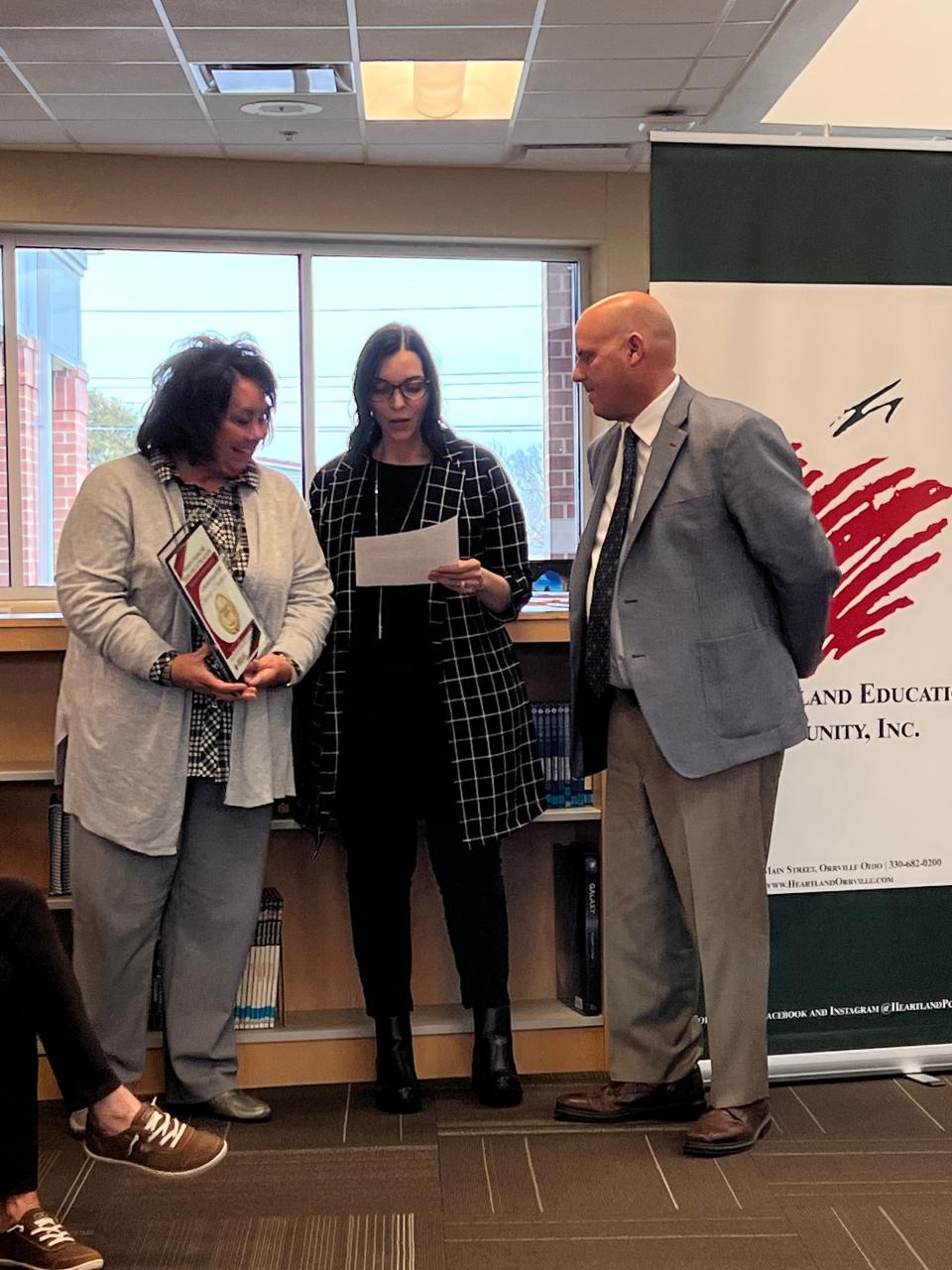 Orrville Elementary Assistant Principal Ashley Millsaps, center, announces Principal Beverly Waseman, left, as Heartland Education Character Employee of the Month as Superintendent Jon Ritchie looks on.