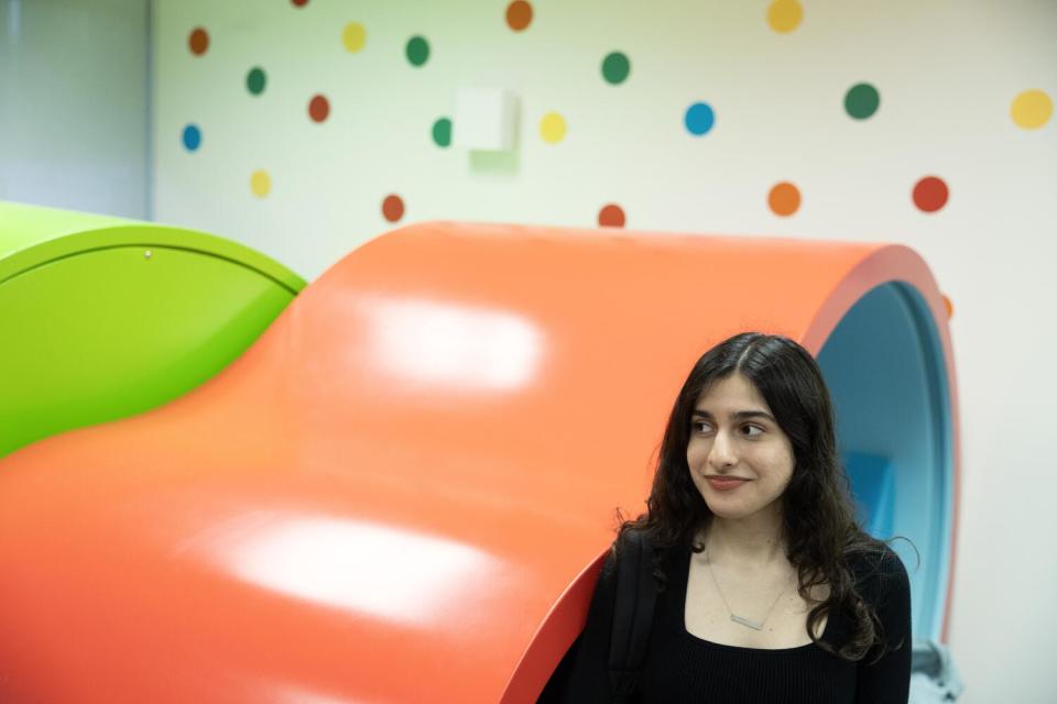 A female college student smiles inside a campus center.