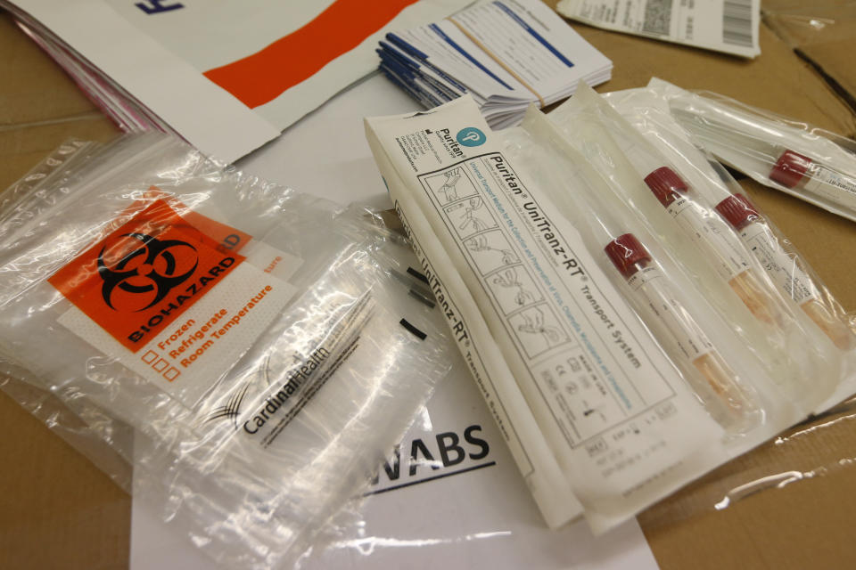 Covid-19 test kits are prepared at the Genetworx clinical lab Wednesday March 25 , 2020, in Glen Allen, Va. Five thousand kits are being flown to Florida for a drive-thru coronavirus  testing site. (AP Photo/Steve Helber)