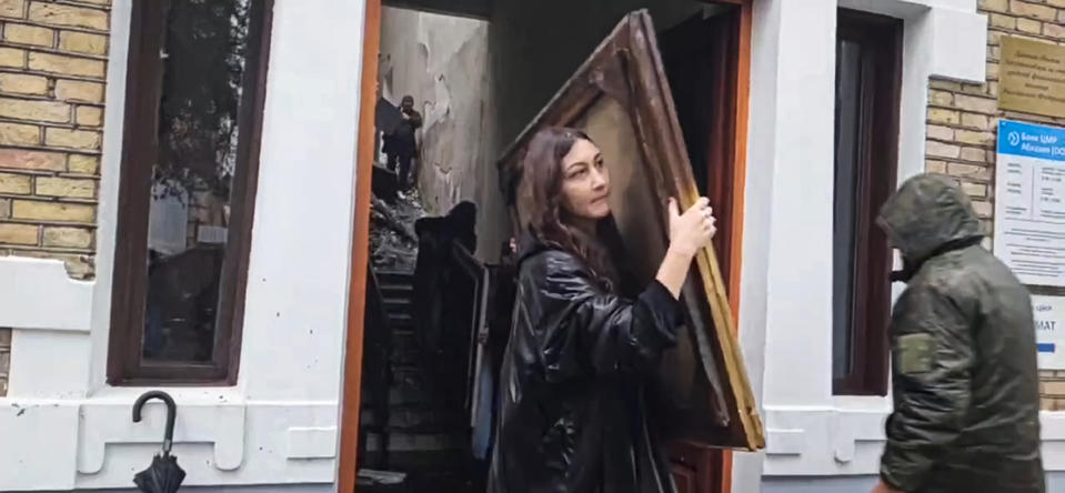 This photo taken from video shows Gallery employees taking out painting from the National Art Gallery in Abkhazia, in Sukhumi the capital of the separatist Georgian region, Sunday, Jan. 21, 2024. Thousands of artworks have been destroyed in a fire that swept through the main art gallery in Abkhazia in a severe blow to the cultural heritage of the separatist Georgian region. (AP Photo/Robert Dzhpua)