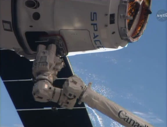 A SpaceX Dragon cargo ship is captured by astronauts using the robotic arm on the International Space Station in this close-up camera view from the outpost on April 20, 2014. The Dragon capsule delivered nearly 5,000 lbs. of supplies to the spa