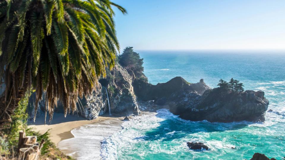 These are the best family beaches in the United States.
Pictured: a rocky California beach with turquoise waters and lush green palm trees