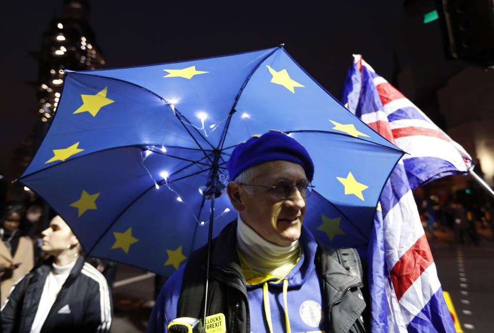 A pro-European demonstrator holds an umbrella in the EU colors at Parliament Square in London, Tuesday, Jan. 15, 2019. Britain's Prime Minister Theresa May is struggling to win support for her Brexit deal in Parliament. Lawmakers are due to vote on the agreement Tuesday, and all signs suggest they will reject it, adding uncertainty to Brexit less than three months before Britain is due to leave the EU on March 29. (AP Photo/Frank Augstein)