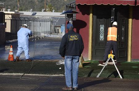 Workers clean up spilled oil at a facility in Los Angeles, May 15, 2014. REUTERS/Phil McCarten