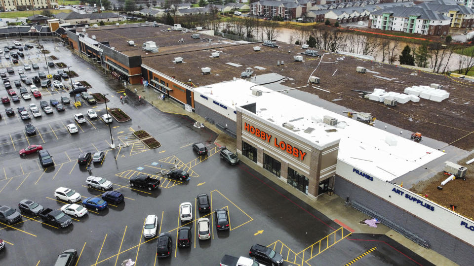 Storm debris sits on the roof top of Hobby Lobby off Scottsville Road in Bowling Green, Ky., after another tornado warning was issued late Saturday morning, Jan. 1, 2022, for Warren and surrounding counties, following the devastating tornadoes that tore through town on Dec. 11, 2021. Though the damage from Saturday's storm proved less catastrophic than the system that passed through in December, heavy rain and strong winds battered the area, causing damage along Cave Mill Road and the surrounding area. (Grace Ramey/Daily News via AP)