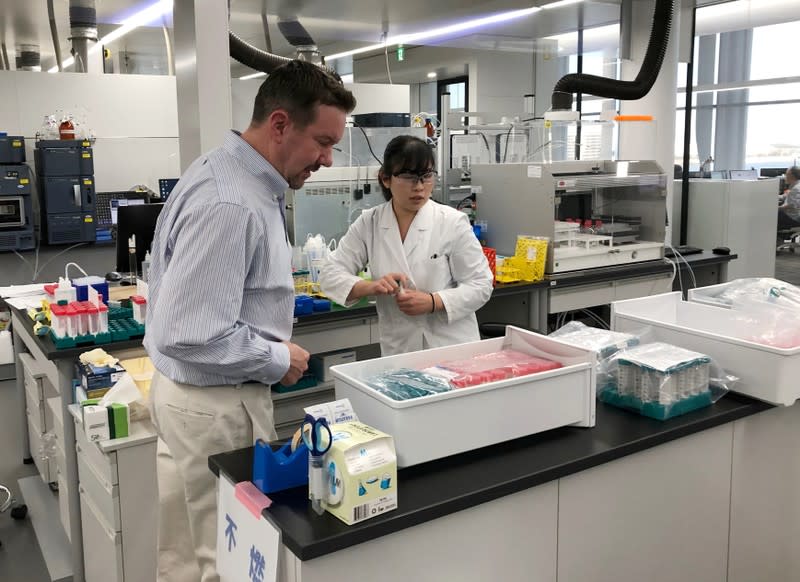 Patrick Reid, President and CEO of PeptiDream Inc, talks with a researcher at the company's laboratory in Kawasaki, Japan