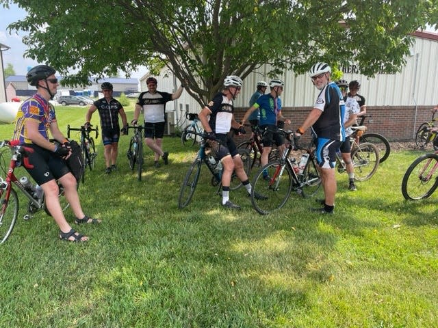 The RAGBRAI pre-ride team crowds into the shade under a tree in Luther as they prepare to pedal to Ames on June 6, 2023.