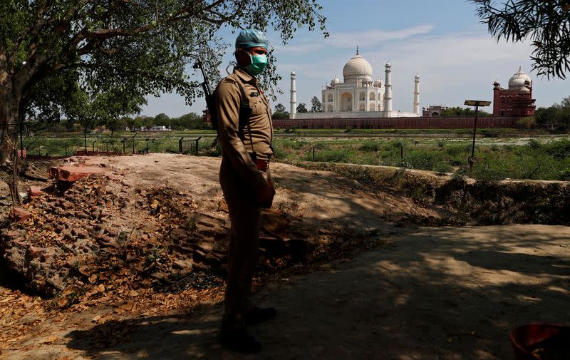 FILE PHOTO: A policeman wearing a protective mask stands guard near the historic Taj Mahal during a nationwide lockdown