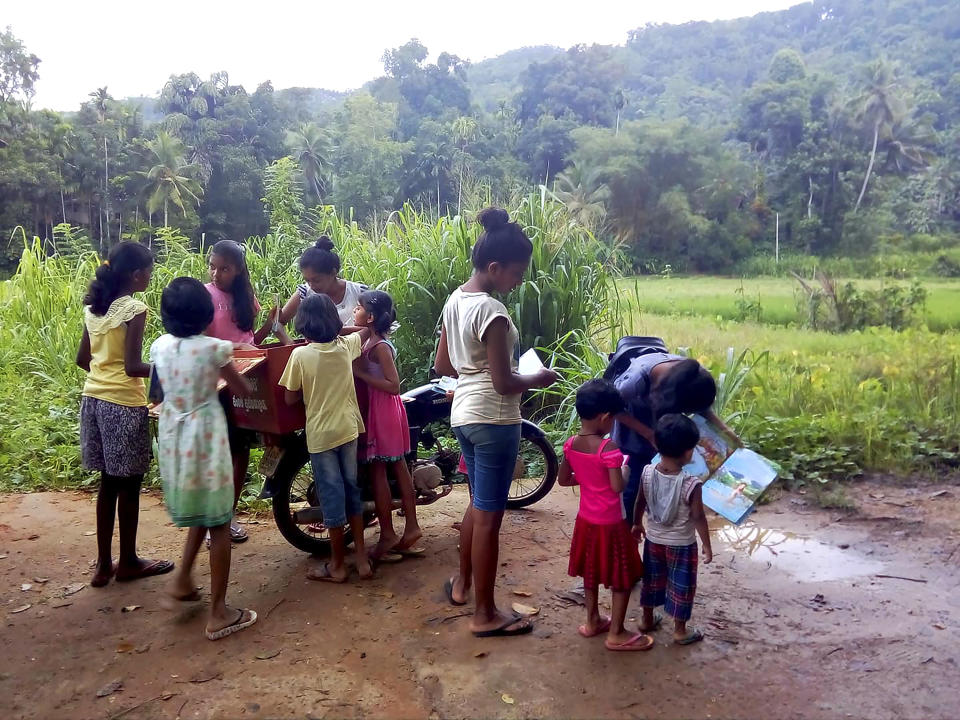 Children look to borrow books from a mobile library run on a motorbike by Mahinda Dasanayaka, in a village in Kegalle district, about 85 kilometers (53 miles) northeast of Sri Lanka's capital, Colombo, July 26, 20019. Having witnessed the hardships faced by children in rural areas whose villages have no library facilities, Dasanayaka got the idea for his library on wheels called “Book and Me." Dasanayaka, 32, works as a child protection officer for the government. On his off days, mostly during weekends, he rides his motorbike, which is fixed with a steel box to hold books, to rural villages and distributes the reading material to children free of charge. (AP Photo)