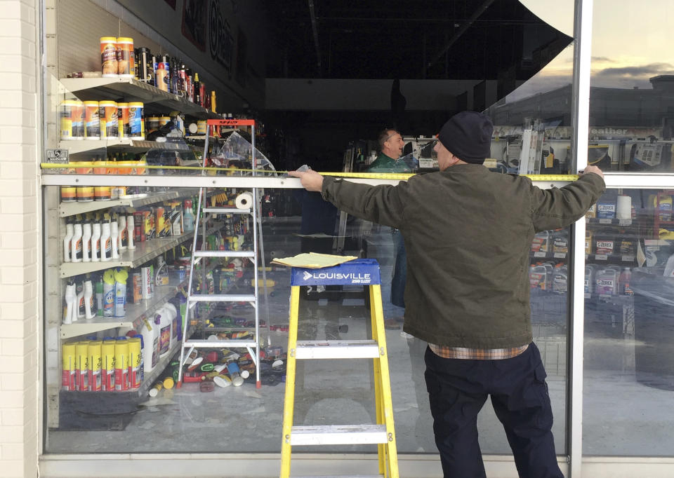 Dennis Keeling measures to replace a broken window at an auto parts store in Anchorage.