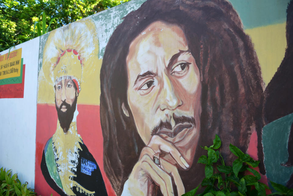 A mural depicting reggae music icon Bob Marley, right, and former Ethiopia's Emperor Haile Selassie decorate a wall in the yard of Marley's Kingston home, in Jamaica, Wednesday, Feb. 6, 2013. Relatives and old friends, joined by hundreds of tourists, celebrated Marley's 68th birthday, in the yard of his his Kingston. The reggae icon died of cancer in 1981 at age 36. (AP Photo/ David McFadden)