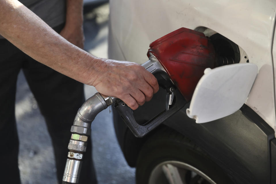 A man fills his car at a gas station in Tehran, Iran Wednesday, Oct. 27, 2021. Iran's President Ebrahim Raisi said Wednesday that a cyberattack which paralyzed every gas station in the Islamic Republic was designed to get "people angry by creating disorder and disruption." Long lines snaked around the pumps a day after the incident began as some stations began selling fuel again although at higher, unsubsidized prices. (AP Photo/Vahid Salemi)