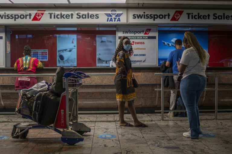 Los pasajeros esperan en un mostrador de boletos en el aeropuerto OR Tambo de Johannesburgo, Sudáfrica