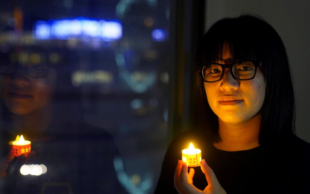 Chow Hang Tung poses with a candle ahead of the 32nd anniversary of the crackdown on pro-democracy demonstrators at Beijing's Tiananmen Square - Reuters