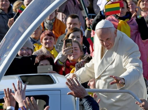 Pope Francis waves as he travels among crowds of followers in Kaunas, Lithuania