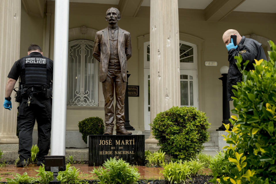 Bullet holes are visible on a column behind a statue of Cuban independence hero José Martí as Secret Service officers investigate after police say a person with an assault rifle opened fire at the Cuban Embassy, Thursday, April 30, 2020, in Washington. Officers found the suspect with an assault rifle and took the person into custody without incident, police said. (AP Photo/Andrew Harnik)